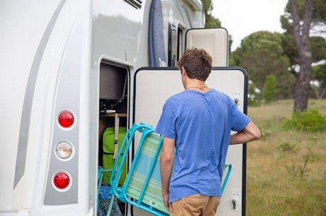 man packing caravan accessories for a trip