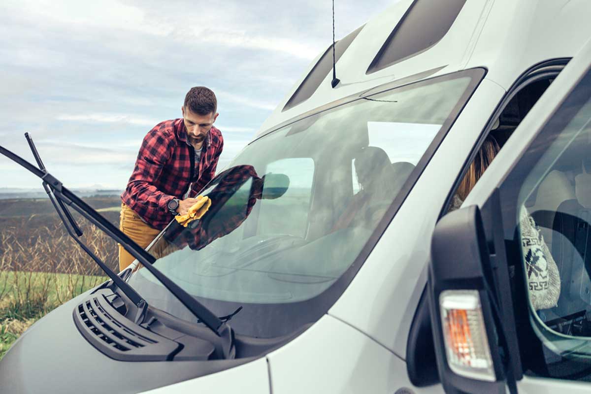man cleaning campervan windows