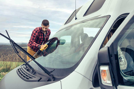 man cleaning campervan windows